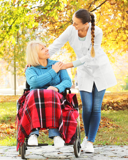 caregiver accompanying her patient on a wheelchair