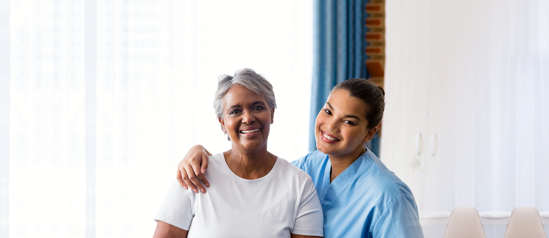 senior woman and her caregiver smiling