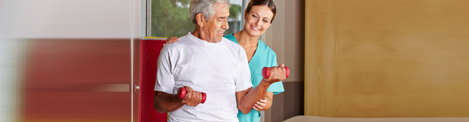 senior man with dumbbells assisting by the occupational therapist